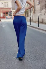 Pantalón flare de tiro medio, color azul, confeccionado en tejido de punto elástico. Cuenta con cintura elástica ajustable con cordón, bolsillos delanteros y corte amplio en las piernas.