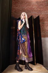 Vestido midi de corte recto y cuello alto, confeccionado en terciopelo con un diseño estampado de estilo patchwork que combina motivos botánicos, geométricos y ornamentales en tonos verdes, violetas, naranjas y marrones.