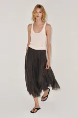 Falda midi de tiro medio de la colección ZARA Woman, confeccionada en mezcla de lyocell con acabado fluido y bajo en línea evasé. Cuenta con forro interior a tono y cierre lateral con cremallera oculta.