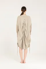 Vestido camisero de cuello mao y corte amplio, confeccionado en popelina de viscosa con mangas de viscosa y seda, con botones en el frente, jaretas ajustables a los costados y largo a la rodilla.