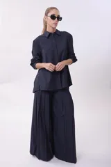 Camisa azul marino de corte amplio, con cuello clásico, mangas largas y cierre frontal con botones.