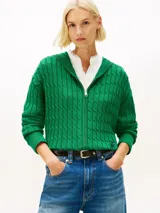 Buzo con capucha de Tommy Hilfiger, confeccionado en tejido de punto cableado color verde. Presenta cierre frontal de cremallera, mangas largas con puños acanalados y logo script bordado en la parte inferior.
