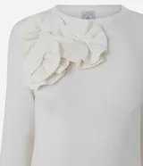 Suéter de punto color blanco, de corte ajustado y manga larga, con cuello redondo y detalle de aplicaciones de flores en relieve sobre el hombro derecho.
