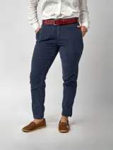 Pantalón de pana negro de corte recto, con bolsillos laterales y traseros. Se ajusta a la cintura con cinturón de cuero negro.