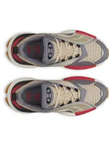 Championes Under Armour modelo UA Arc 96, con diseño futurista de inspiración retro. Capellada de malla múltiple en tono beige con superposiciones de cuero y paneles laterales translúcidos. Incorpora detalles en gris, negro y un toque de rojo, con entresuela voluminosa y suela de goma color caramelo.