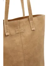 Cartera tipo tote bag color tostado, de diseño amplio y estructurado, con doble asa larga para hombro y costuras decorativas frontales.