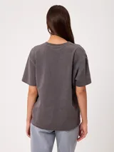 Remera de algodón gris con efecto de lavado ácido y corte holgado, con amplio estampado frontal de diseño inspirado en surf y estilo vintage.