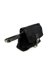 Cartera de gamuza y cuero sintético negro, con solapa frontal, tira ajustable para el hombro y detalle de hebilla metálica dorada en el cierre.