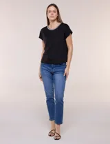 Blusa de silueta recta confeccionada en crepe elastizado, color negro, con escote a la base destacado con una delicada tira aplicada de perlas y cuentas, mangas cortas dollman y ruedo recto.
