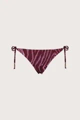 Calzón de bikini con tiras laterales ajustable, con estampado animal print tipo cebra en tonos bordó y rosado, y detalle de cuentas en los extremos de los cordones.