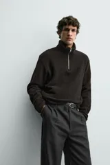 Sudadera de corte regular confeccionada en tejido de borreguillo con textura, cuello subido con cierre frontal de cremallera y manga larga con acabados en cinta.