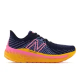 Championes de running New Balance WVNGOEM5 para dama, color azul marino con detalles en rosa y amarillo.