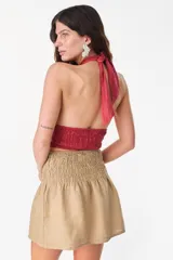 Minifalda de lino color rojo, de tiro alto con pretina fruncida y diseño holgado.