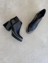 Botín de cuero color marrón con plataforma y taco geométrico.