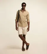 Bermuda masculina de sarga color rosa, corte slim, con bolsillos laterales y cierre con botón y cremallera.