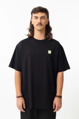 Remera negra de algodón con estampa en la espalda de una ilustración de Adrian Willard que representa una mujer con una rosa en el pelo y un cráneo fumando, sobre un fondo con damero y texto en japonés.