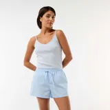 Camiseta de tirantes finos con escote en V decorado con puntilla y un pequeño lazo central. Presenta un tejido de algodón con textura sutil.