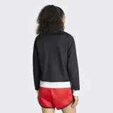 Campera deportiva Adidas Originals, modelo clásico Adicolor Firebird, de color negro con detalles en blanco. Presenta cierre frontal completo, cuello alto tipo embudo, bolsillos laterales con cierre y las icónicas tres tiras blancas en las mangas. El logo del trifolio de Adidas está bordado en el pecho.