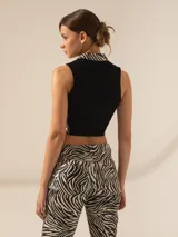 Top corto de cuero ovino con estampado de cebra, cuello alto y cierre metálico frontal.