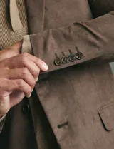 Saco sport de gamuza ecológica, con cierre de dos botones frontales, solapas clásicas y bolsillos laterales con solapa.