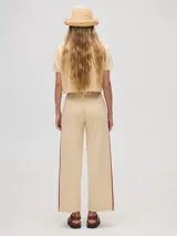 Pantalón de punto color verde oliva, confeccionado en algodón, con corte holgado, pierna ancha y tiro alto. Cuenta con pretina elástica con cordón de ajuste y una línea lateral a contratono en color naranja.
