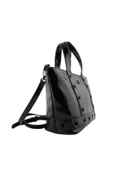 Cartera tipo tote de Las Oreiro en color negro, con acabado brillante. Presenta detalles de ojales metálicos decorativos en el frente y en la base, junto con un pequeño logo en forma de labios. Incluye doble asa de mano y correa larga ajustable y extraíble.