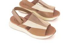 Sandalias de cuero combinadas en tonos tostado, nude y detalles metalizados dorados, con diseño de tiras cruzadas y textura efecto reptil en la parte superior. Cuentan con suela de plataforma baja y tira ajustable en el talón.