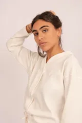 Conjunto de pijama color crema, compuesto por una camisa de manga larga con botones y un pantalón largo con elástico en la cintura ajustable con cordón.