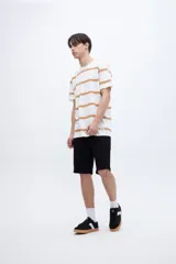 Remera de algodón color crudo con rayas horizontales negras, de corte recto y manga corta.