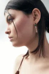 Aros colgantes largos con base dorada y apliques de strass de colores.