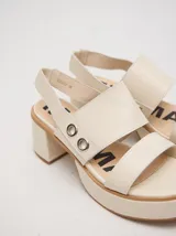 Sandalias de plataforma con taco bloque, capellada de tiras anchas de cuero con detalles de argollas metálicas y tira trasera elástica.