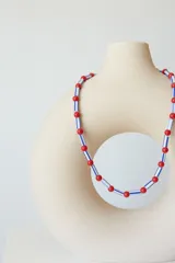 Collar tipo choker de cuentas plásticas en colores verde lima y amarillo, con diseño de cuentas cilíndricas y esféricas intercaladas. Incluye una cadena de extensión para ajustar el largo.
