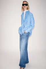 Camisa ZW Collection de algodón, con diseño a rayas verticales celestes y blancas, cuello solapa, manga larga y bolsillo de parche en el pecho con cierre frontal de botones ocultos.
