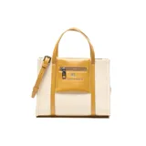 Cartera tipo tote de material textil color beige con detalles y asas en cuero sintético color mostaza. Cuenta con un bolsillo externo frontal con cierre y el logo de la marca impreso, doble asa de mano y correa de hombro ajustable y desmontable.