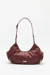 Cartera de hombro color bordó, de símil cuero, con diseño curvo y detalles de cierres metálicos en los extremos.