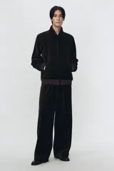 Cazadora de terciopelo de algodón color marrón oscuro, con cuello solapa, cierre frontal de cremallera y bolsillos frontales de vivo. Presenta rib elástico a tono en puños y bajo.