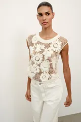 Top de crochet color crudo, sin mangas, con cuello redondo y detalle de aplicaciones de flores en relieve.