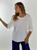 Blusa holgada de manga tres cuartos, color gris claro, con cuello redondo y textura ligera.