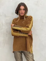 Sweater de cuello alto color marrón con patrón de espiga y detalles de rayas doradas en las mangas y aberturas laterales.