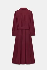 Vestido midi de estilo camisero color bordó, con cuello solapa, escote en pico y cierre frontal con botones ocultos. Presenta manga larga, bolsillos laterales ocultos, solapas decorativas en el pecho y cinturón de lazada en el mismo tejido.