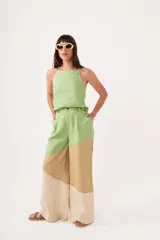 Pantalón de tiro alto con corte palazzo, color beige con bloques de color en marrón claro y blanco.