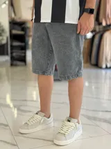 Bermuda de jean de corte baggy y tiro medio, con diseño clásico de cinco bolsillos y lavado claro.