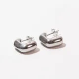 Aros tipo argolla gruesa de acero inoxidable color plateado.