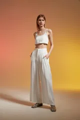 Top corto color crudo, con breteles finos y escote redondo.