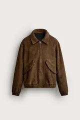 Cazadora de hombre regular fit confeccionada en tejido efecto ante, con acabado lavado, cuello solapa, manga larga, bolsillos de plastrón con solapa en la cadera, detalles elásticos en puños y cintura, y cierre frontal de cremallera.