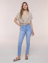 Jean slim skinny de tiro medio en denim celeste, con calce ajustado, bolsillos delanteros y traseros, y cierre frontal con botón y cremallera.