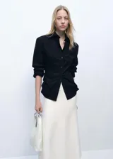 Falda midi de tiro medio con diseño peplum en la cintura y tejido de punto fino. Presenta un corte fluido y elástico sin cierre.