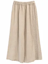 Pantalón wide leg de lino color beige, con cintura elástica fruncida y detalles de costuras pespunteadas con bordados geométricos en los laterales.
