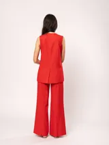 Chaleco color crema de lino con corte sastrero, largo a la cadera, forro interno, botones delanteros, silueta levemente entallada y tajo cruzado en la espalda.