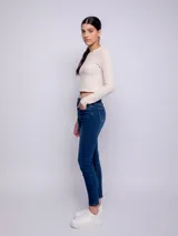 Pantalón de jean chupín color azul medio, con cinco bolsillos, presillas, botón y cierre metálico.